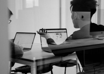 Jasne biuro z laptopem i monitorem podczas pracy nad stroną internetową