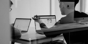 Jasne biuro z laptopem i monitorem podczas pracy nad stroną internetową