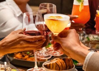 Guests toasting cocktails at dinner