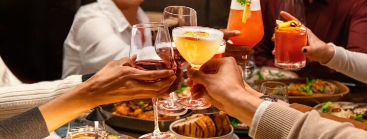 Guests toasting cocktails at dinner