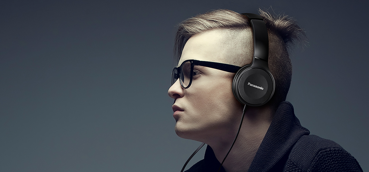 Člověk má na uších sluchátka Panasonic RP-HF100