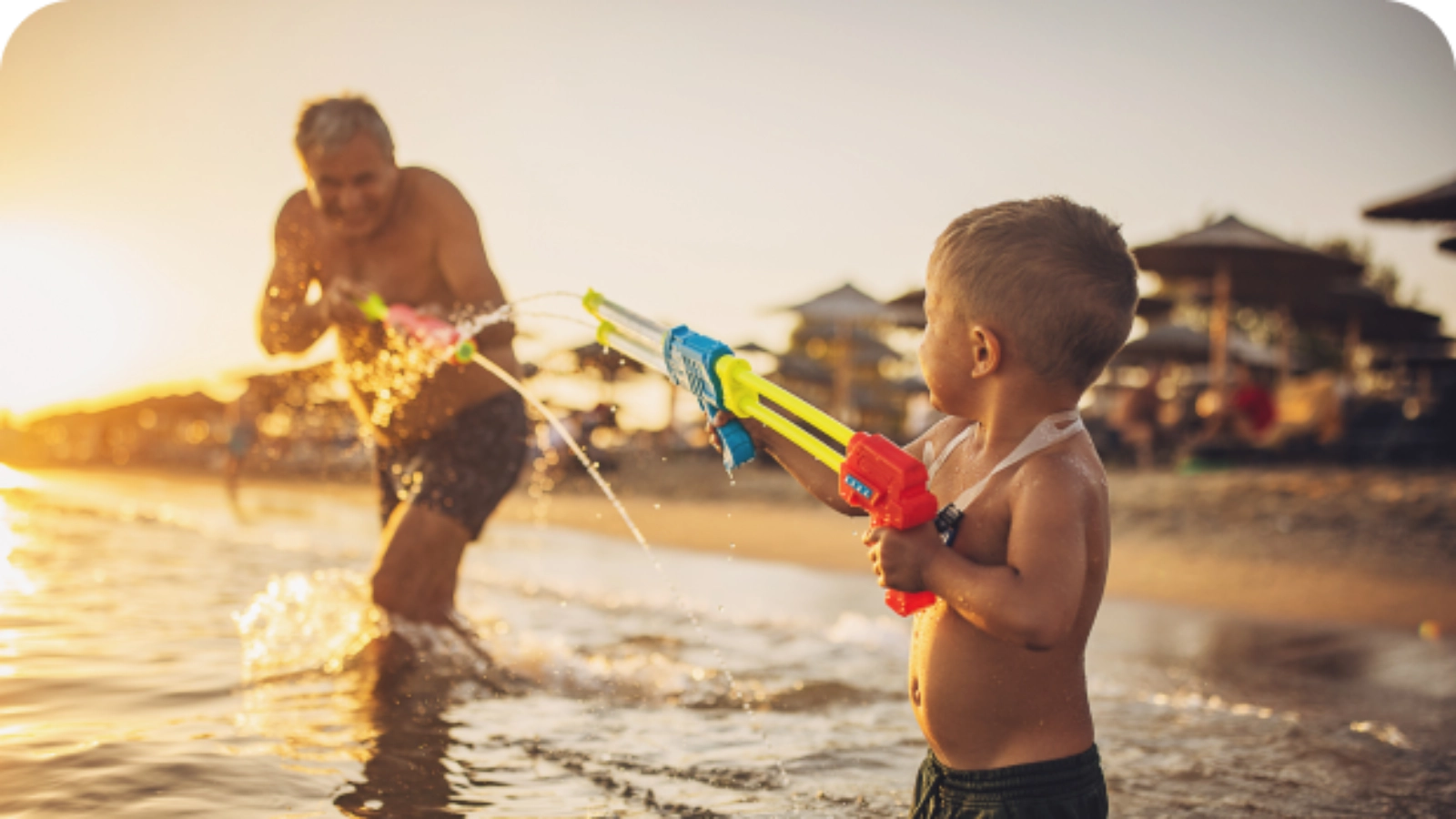 Grandfather and grandson playing by the sea