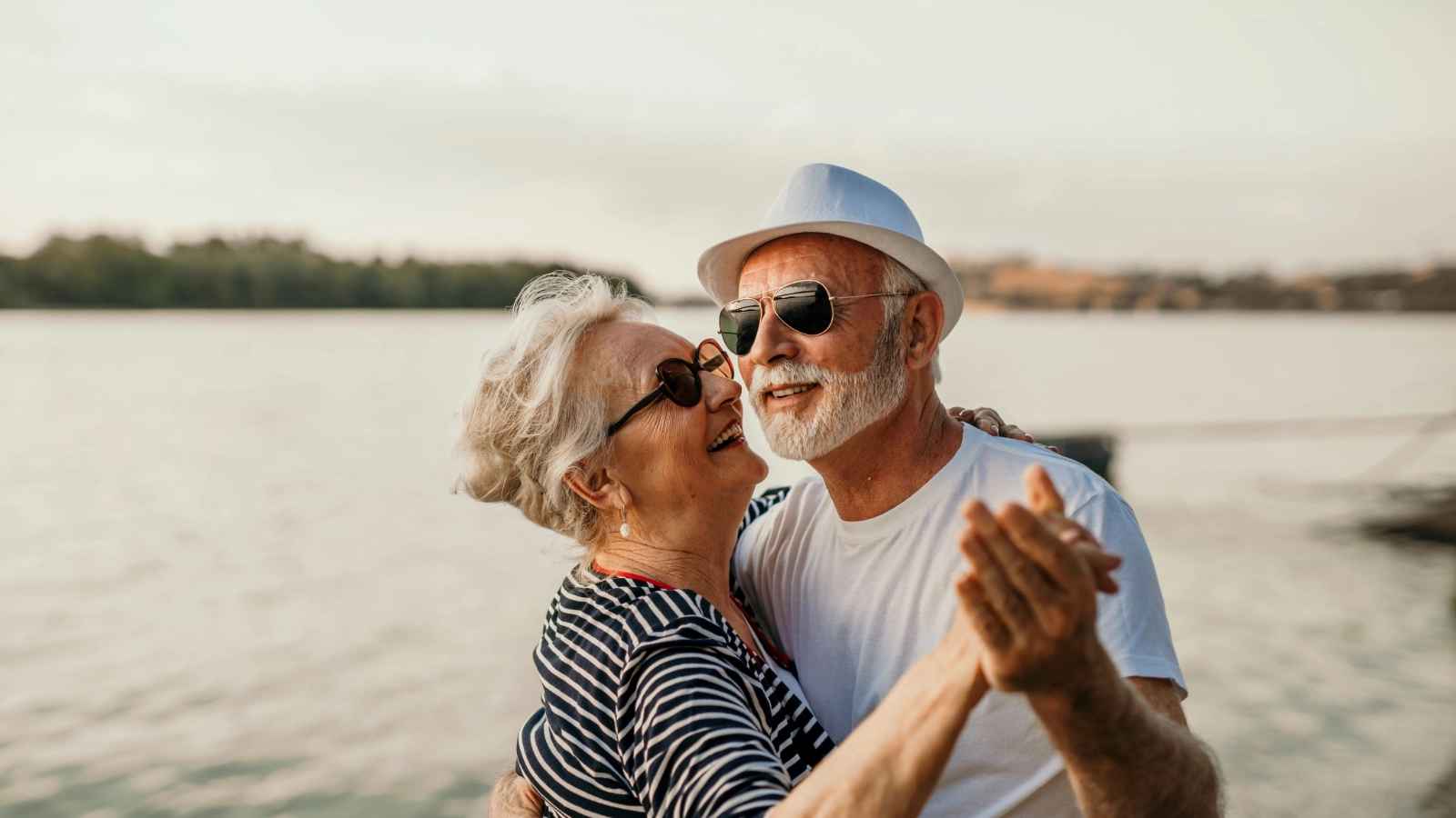 Older couple dancing beside the water