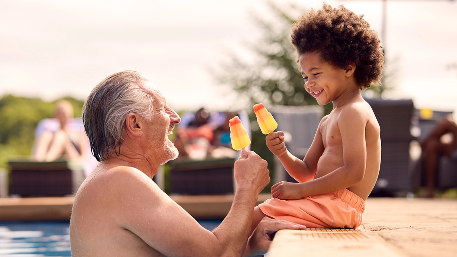 Older man and child beside a pool