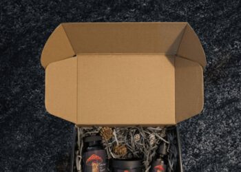 Open Sacred By Sam gift box with botanical products arranged in shredded paper
