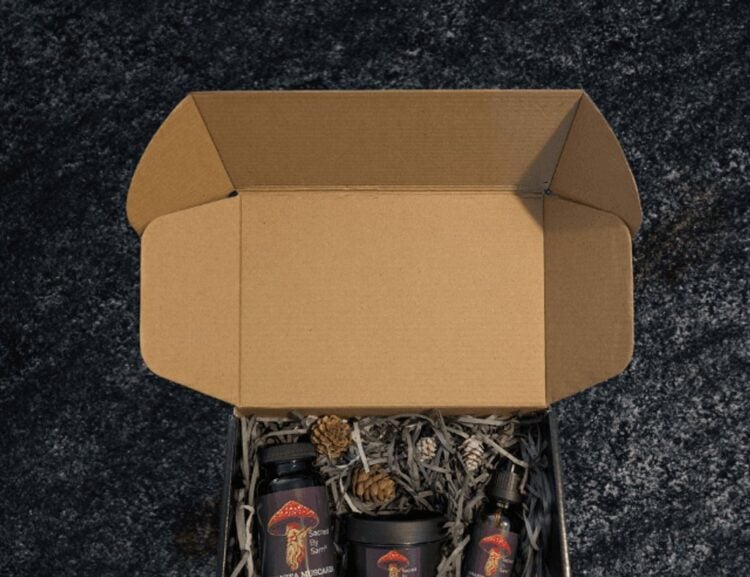Open Sacred By Sam gift box with botanical products arranged in shredded paper