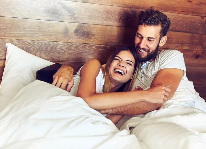A couple laughing together on a Sleep EZ latex bed