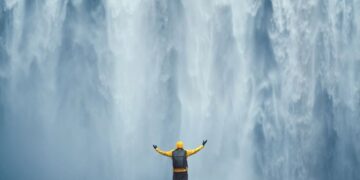 Traveller standing beneath a waterfall