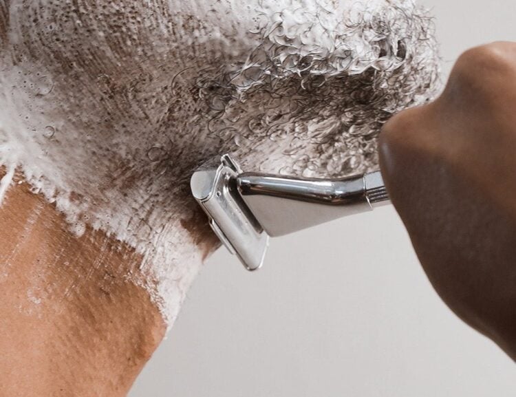 Person shaving with a razor