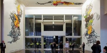 Visitors walking through an art-filled interior at AT&T Stadium