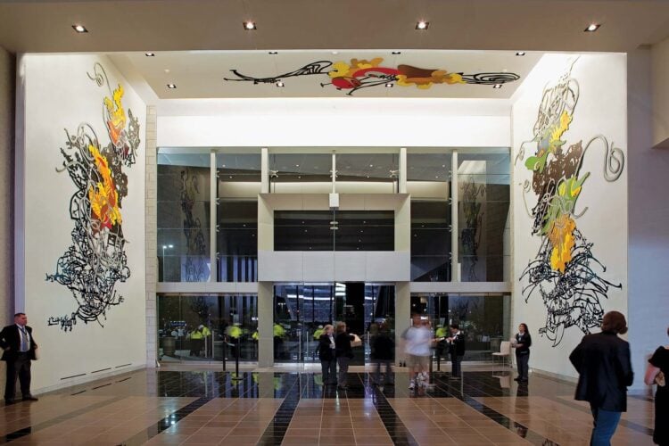 Visitors walking through an art-filled interior at AT&T Stadium