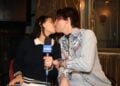 Two people kissing with a microphone