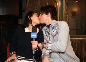 Two people kissing with a microphone