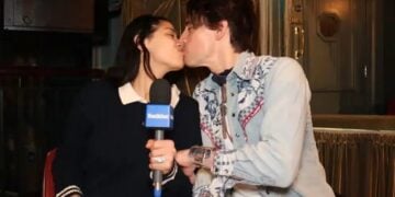 Two people kissing with a microphone