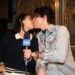 Two people kissing with a microphone