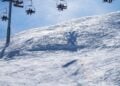 Skiers riding chairlifts above a snowy mountain