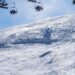 Skiers riding chairlifts above a snowy mountain