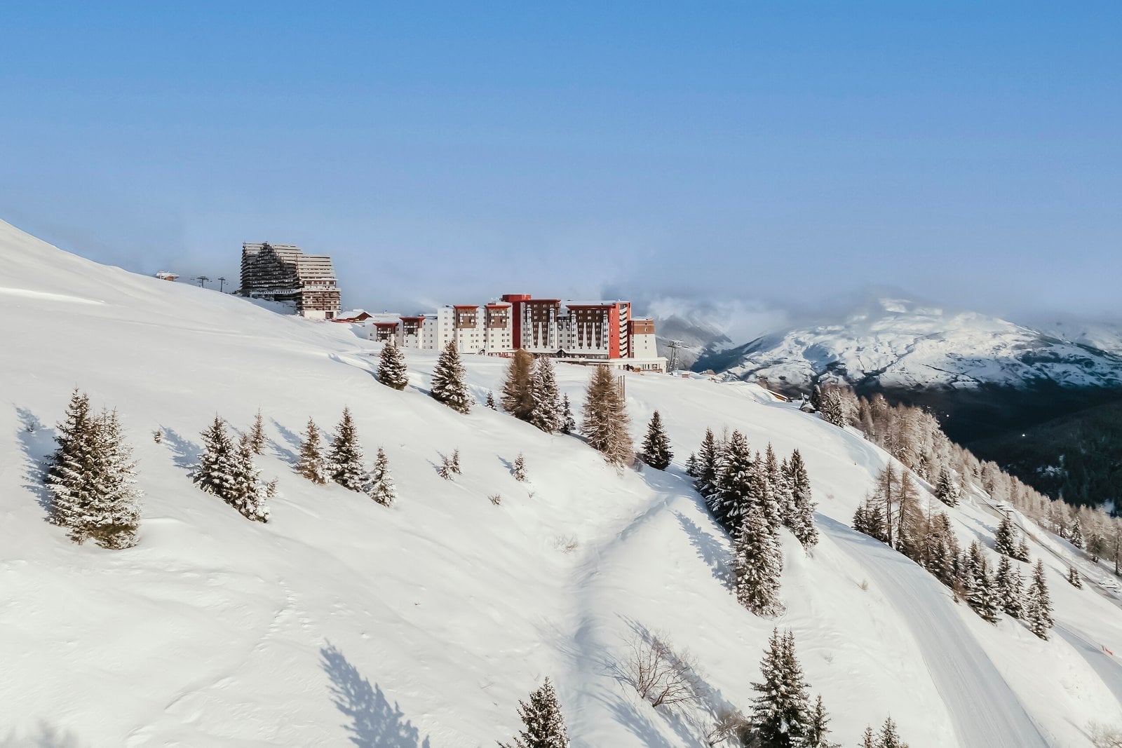 Snow-covered Alpine resort buildings and mountains