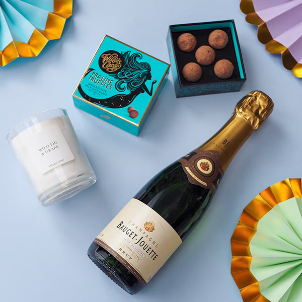 Champagne truffles and a candle arranged as a gift