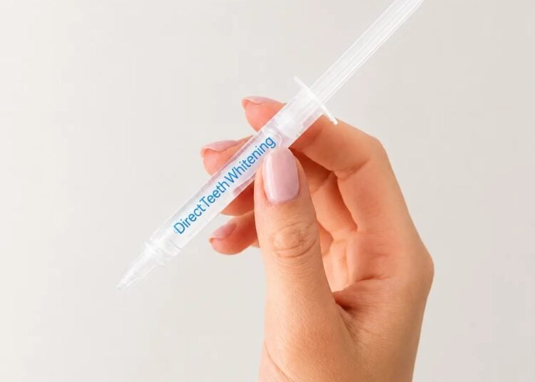 Direct Teeth Whitening Premium gel syringe held in hand