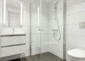 White bathroom with a glass shower and vanity