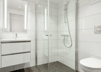 White bathroom with a glass shower and vanity