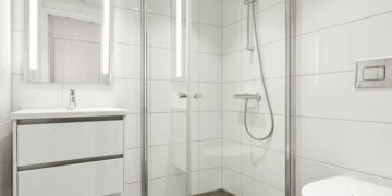 White bathroom with a glass shower and vanity