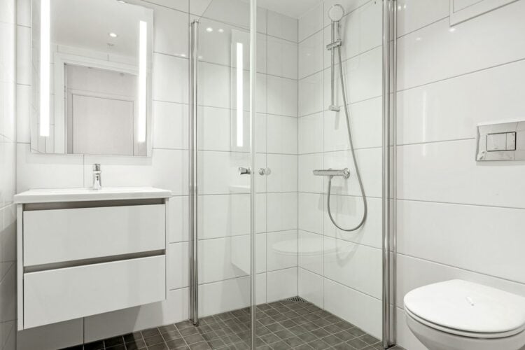 White bathroom with a glass shower and vanity