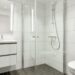 White bathroom with a glass shower and vanity