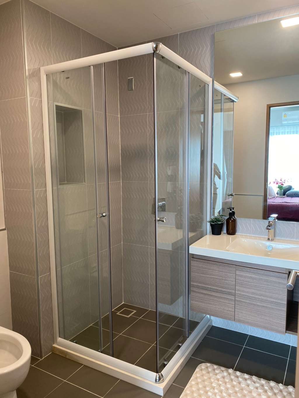 Corner shower enclosure with sliding doors and grey tile