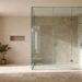 Frameless shower screen in a stone-tiled bathroom