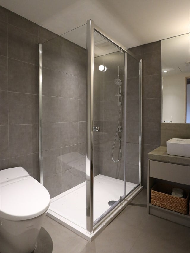 Framed glass corner shower in a tiled bathroom