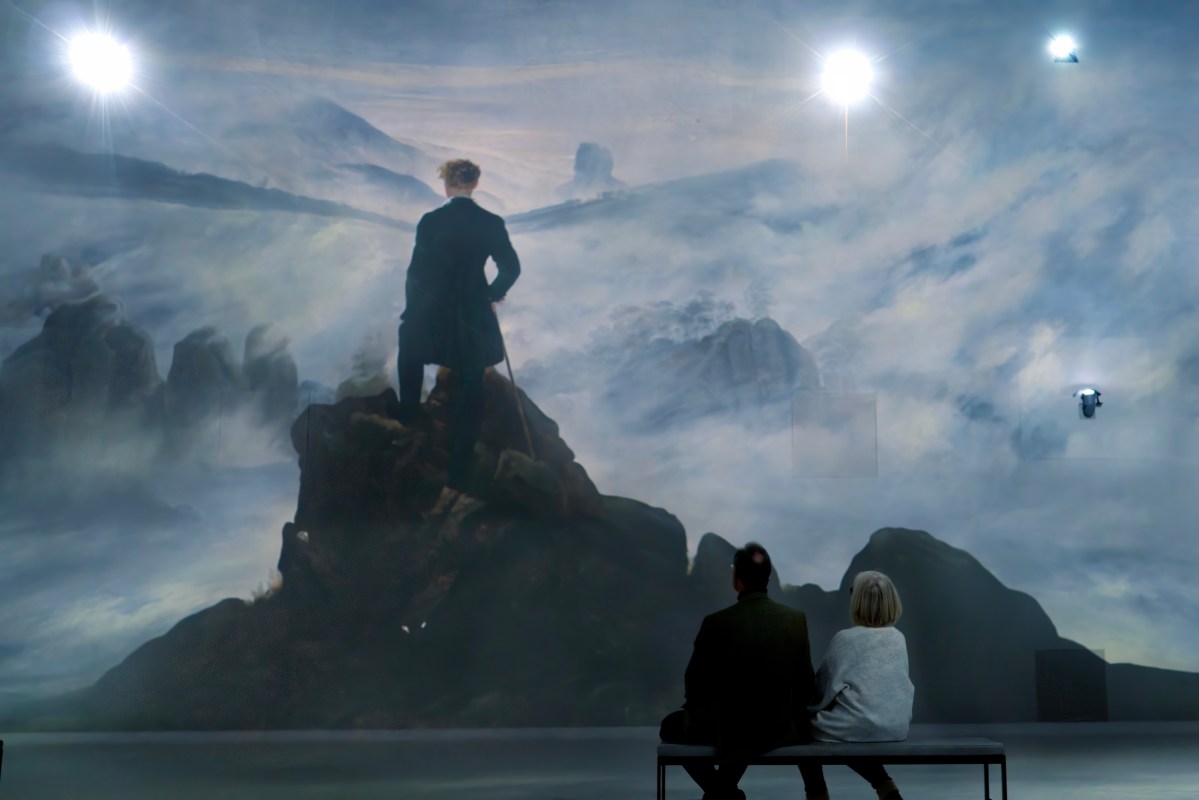 Visitors seated before a projected landscape in a Frameless gallery