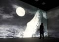 Visitors encounter a large illuminated whale image inside Frameless
