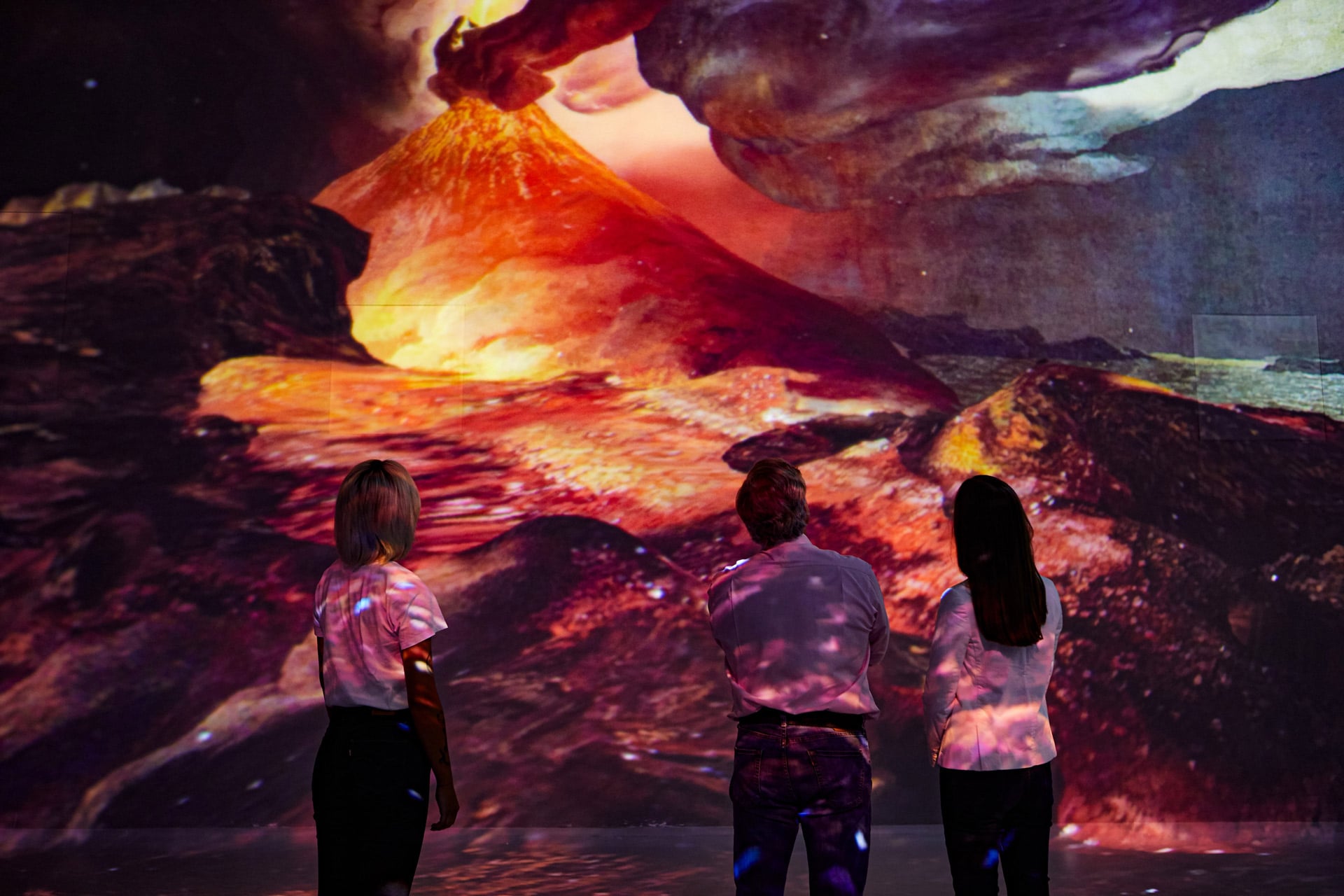 Visitors viewing a volcano projection inside Frameless