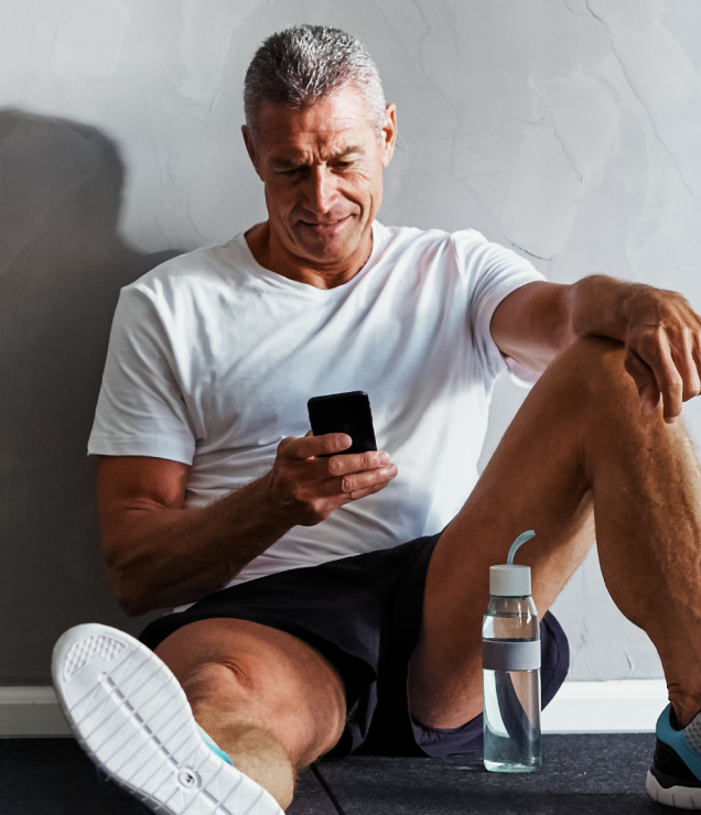 Mann prüft sein Smartphone nach dem Training