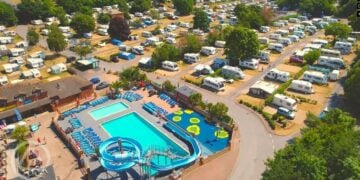 Aerial view of a holiday park with swimming pools and caravans