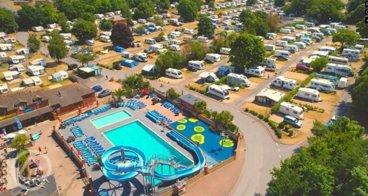 Aerial view of a holiday park with swimming pools and caravans