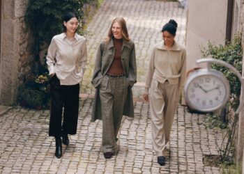 Drei Personen tragen Lilysilk-Mode in einer gepflasterten Gasse