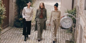 Drei Personen tragen Lilysilk-Mode in einer gepflasterten Gasse