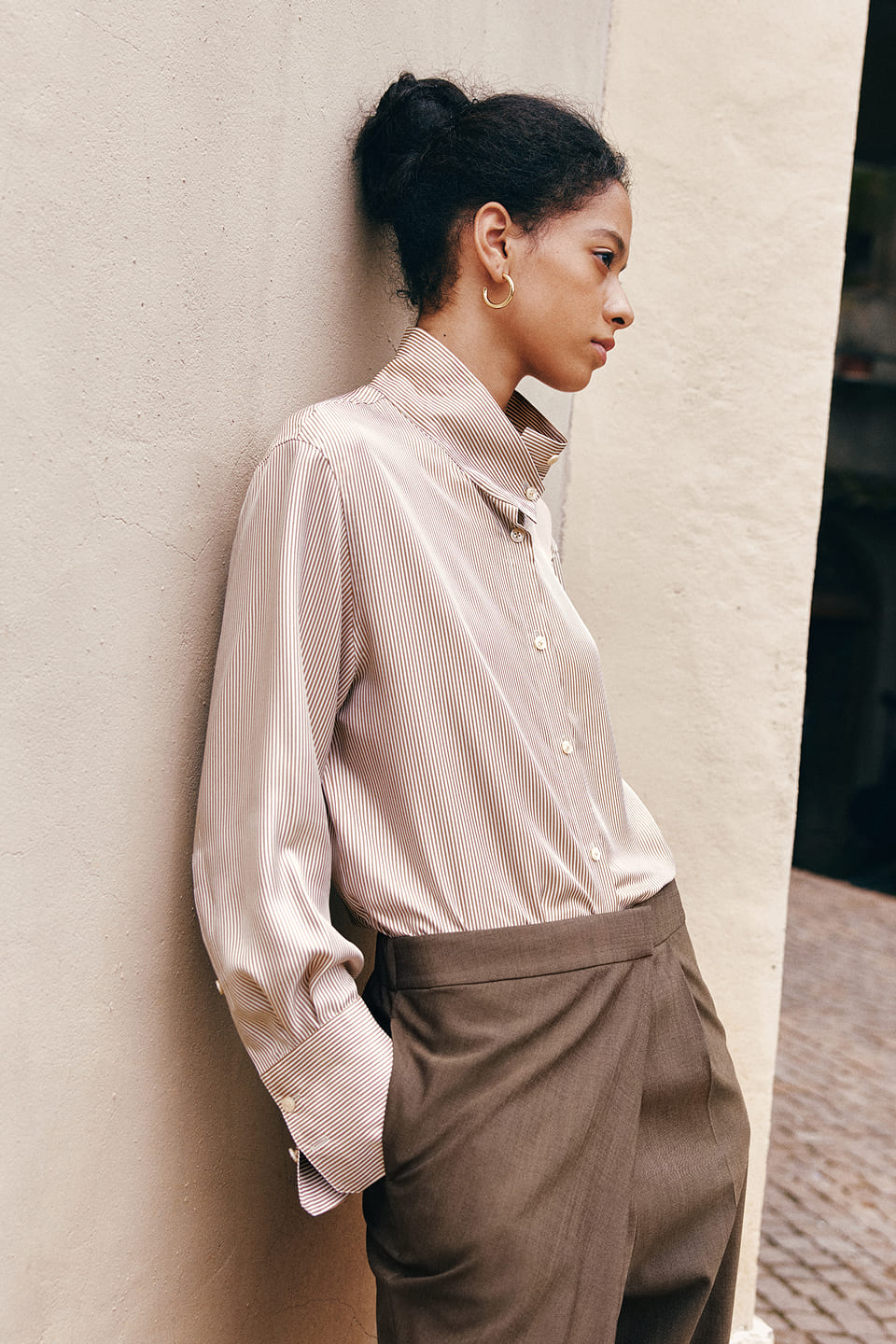 Person in einer hellen Seidenbluse mit dunkler Hose
