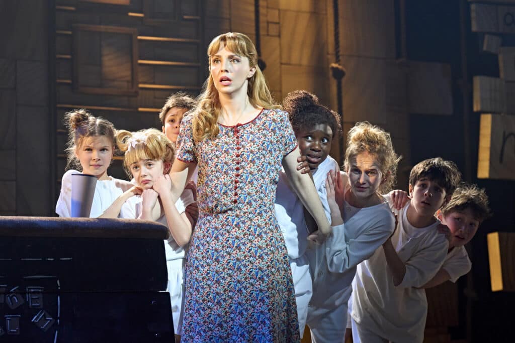 Cast members performing in a distinct London stage moment
