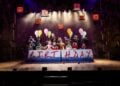 Cast performing together in a Matilda stage scene