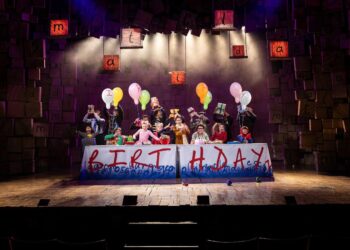 Cast performing together in a Matilda stage scene