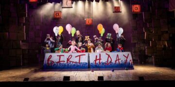 Cast performing together in a Matilda stage scene