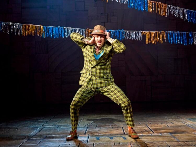 A performer and cast in a Matilda stage scene