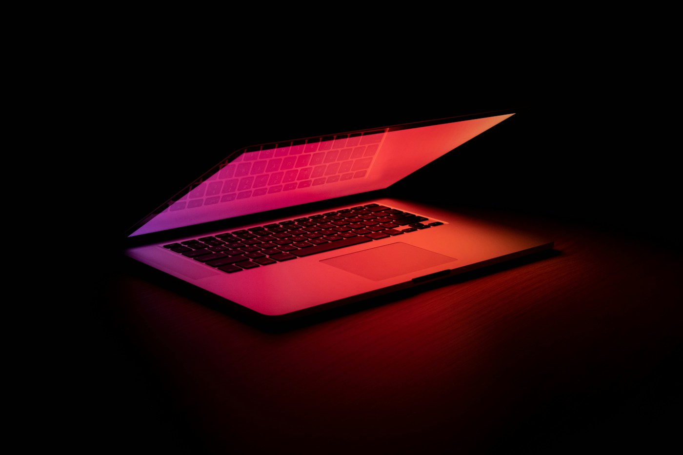 Otwarty laptop oświetlony kolorowym światłem