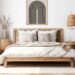 Framed black and cream abstract poster above a bed in a neutral bedroom
