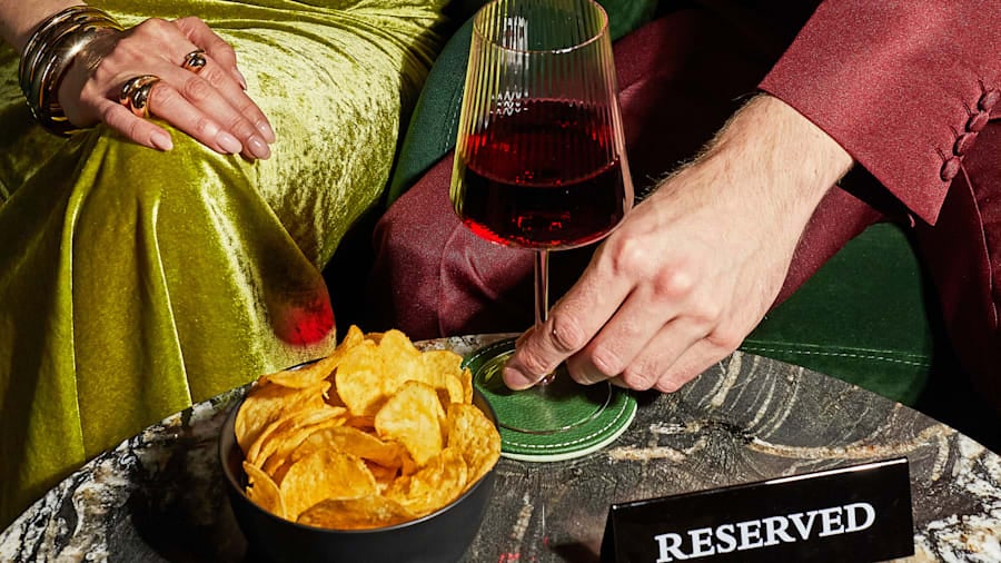 Guests seated at a reserved theatre lounge table with drinks and snacks