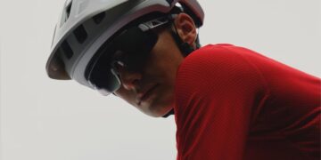 Cyclist wearing a white POC helmet and red jersey